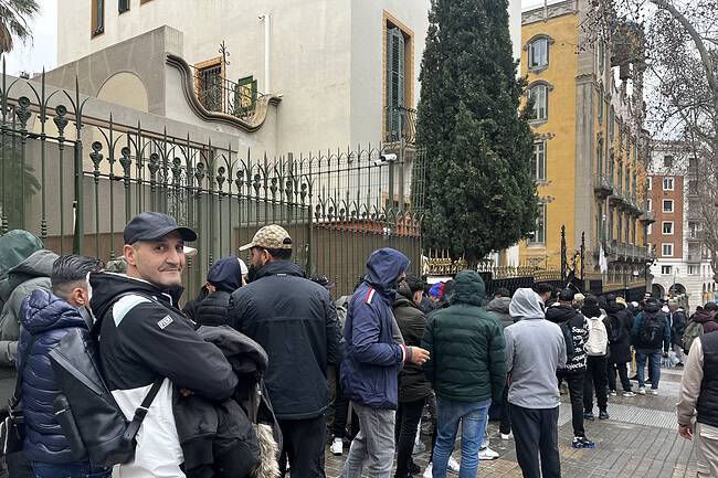 Cola de inmigrantes pidiendo regularización en la embajada de España.
