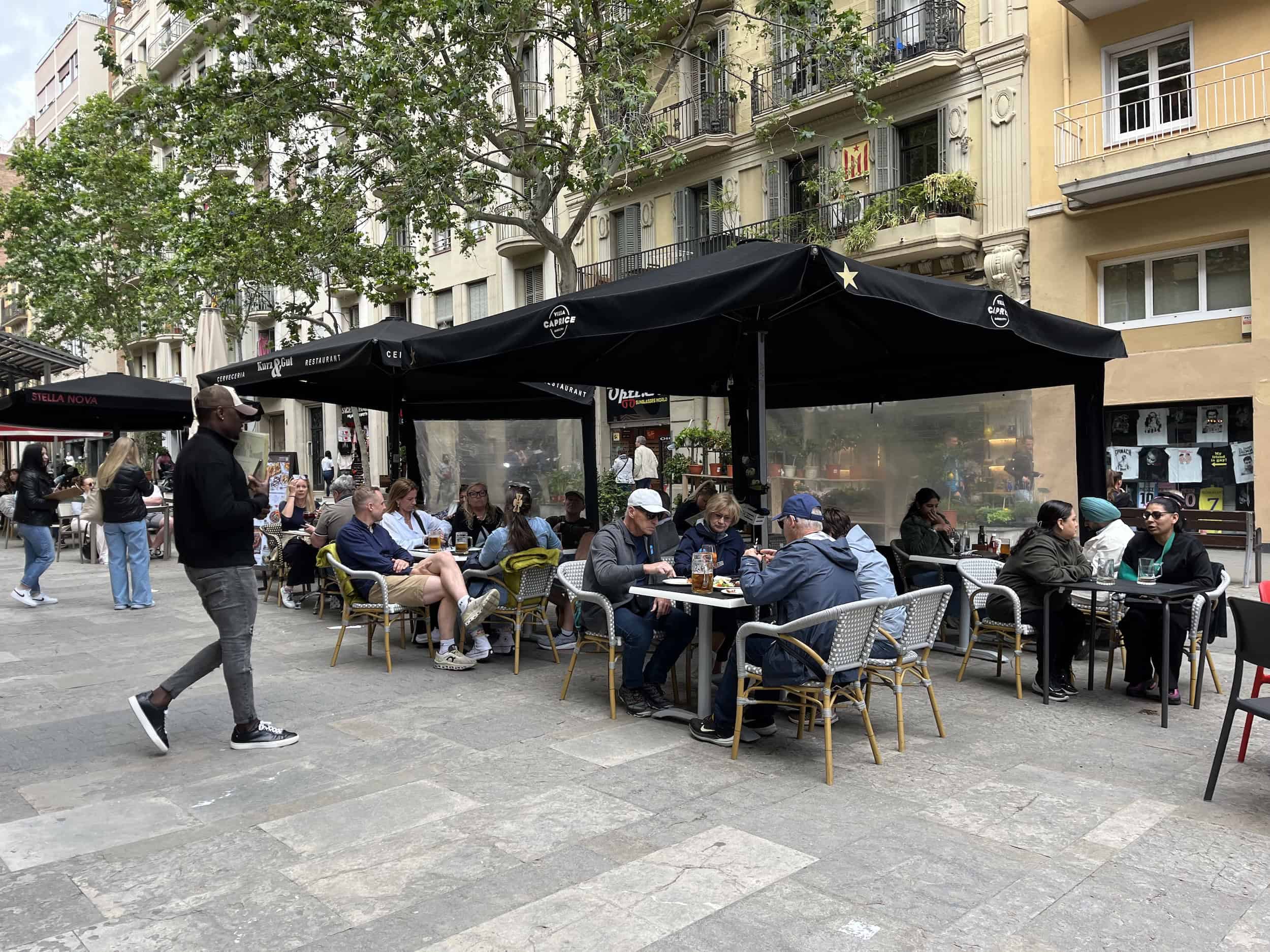 Restaurantes trampa para turistas en Barcelona: "ningún español se comería esto" 6 Terraza de restaurante en Barcelona con clientes y sombrillas negras.