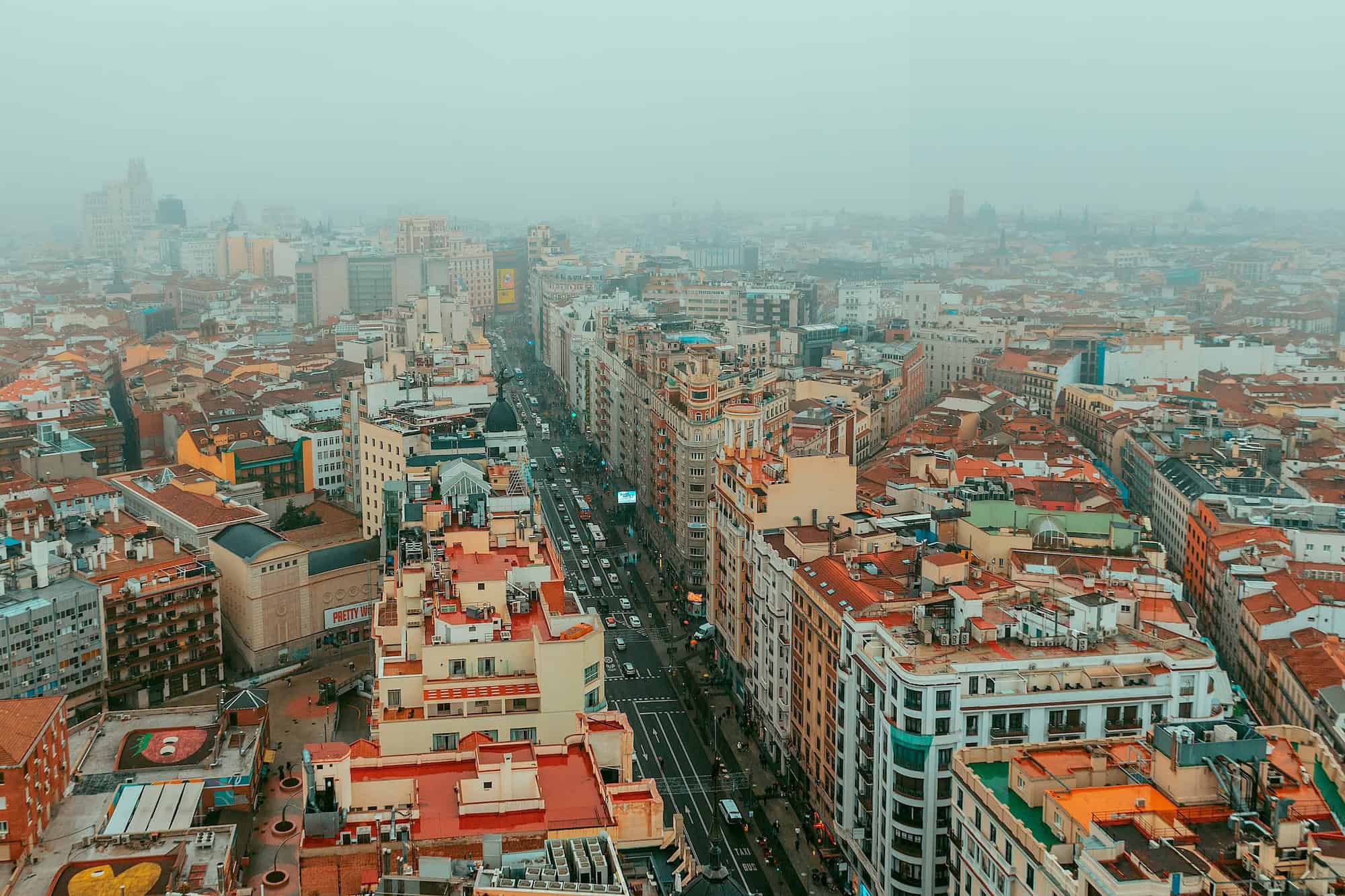 Vista panorámica de una ciudad europea con arquitectura variada y cielo brumoso.