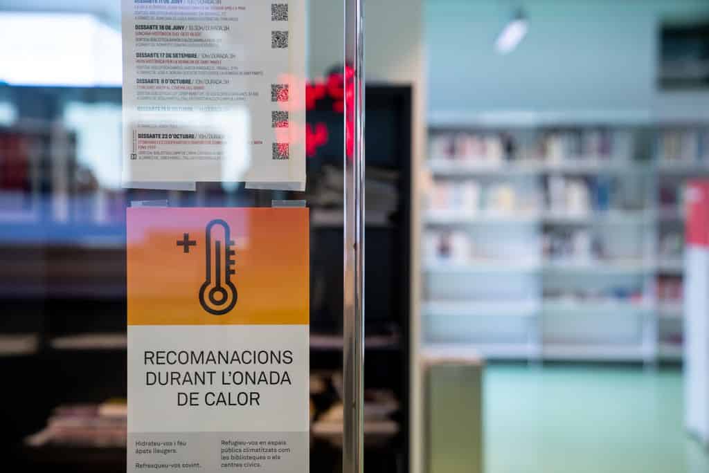Cartel que ofrece recomendaciones para gestionar el calor de la oficina durante una ola de calor en Barcelona, ​​destacando la importancia del aire acondicionado para el confort y la productividad.