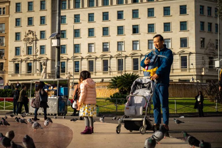 Familia padre niño cochecito Plaça Catalunya palomas foto Clementine Laurent