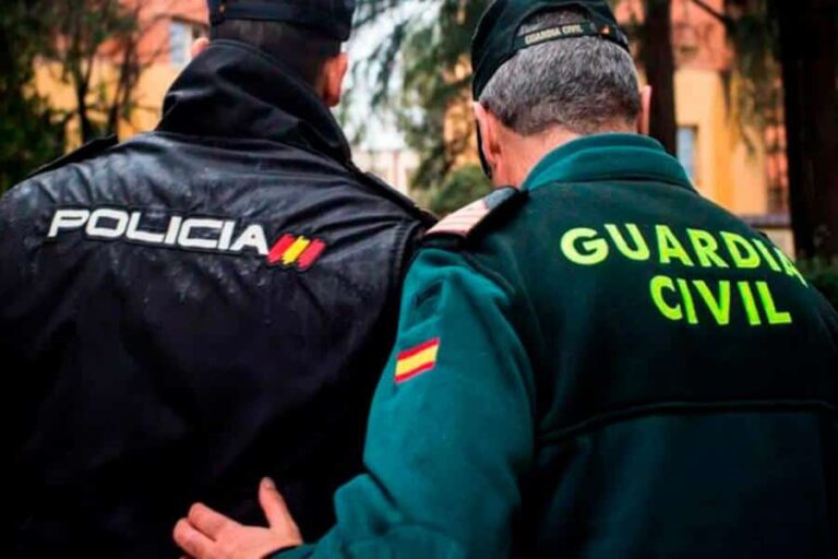 Dos agentes de policía y la Guardia Civil española conversan, simbolizando la cooperación entre las fuerzas del orden en el contexto de la inmigración ilegal.