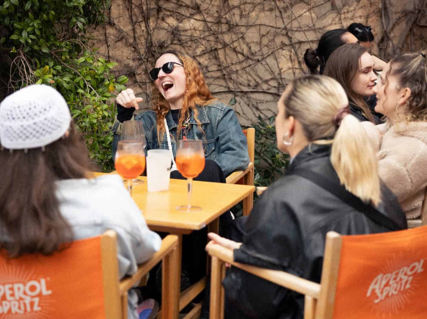 España, mejor calidad de vida del mundo: 7 razones para mudarse allí 6 Grupo de amigos disfrutando de una tarde soleada en una cafetería de Barcelona, disfrutando de bebidas refrescantes y compartiendo un momento agradable.